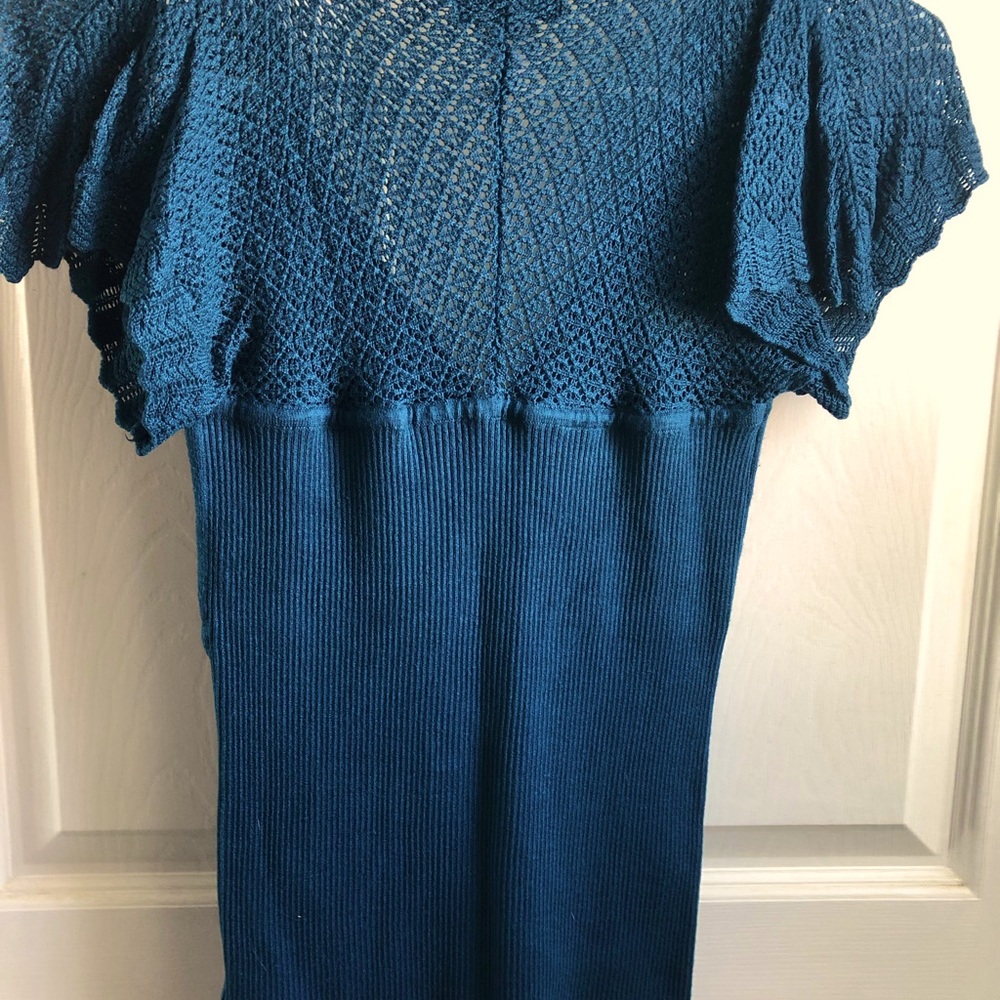 Woman’s blue knit top.